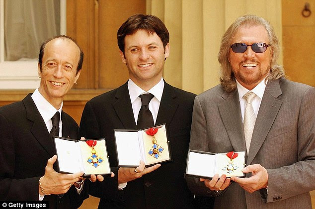Proud: The two surviving Bee Gees members as of May 2004, Robin (left) and Barry (right), hold their CBEs with Adam Gibb who received one on behalf of his father, the late Maurice, at Buckingham Palace in London