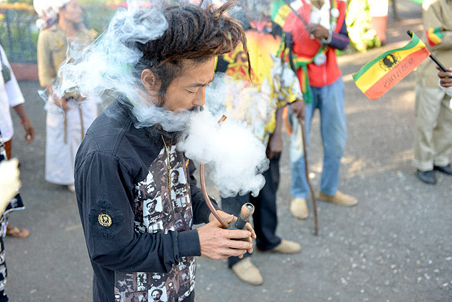 Homem fuma maconha em frente a museu de Bob Marley em Kingston, a capital jamaicana