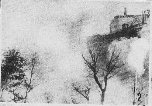 El Alcázar de Toledo envuelto en humo en pleno bombardeo