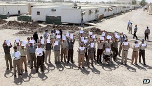 Members of the Mujahideen-e-Khalq hold banners during a tour organised by the Iraqi government for foreign diplomats in Baghdad on 11 Sep 2012.