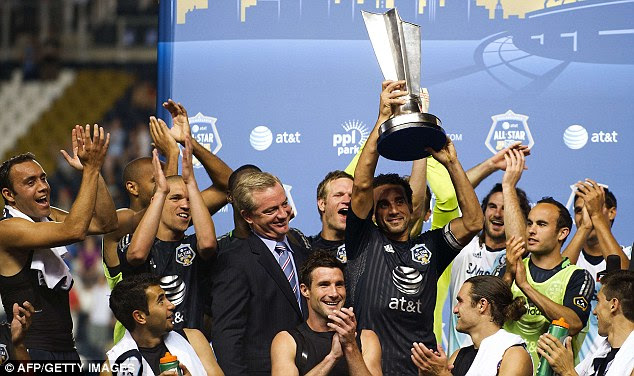 Up for the cup: All Stars captain Dwayne De Rosario lifts the trophy after the match