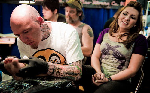 Tattoo Expo : cute girl enduring the pain with a beautiful smile image by 