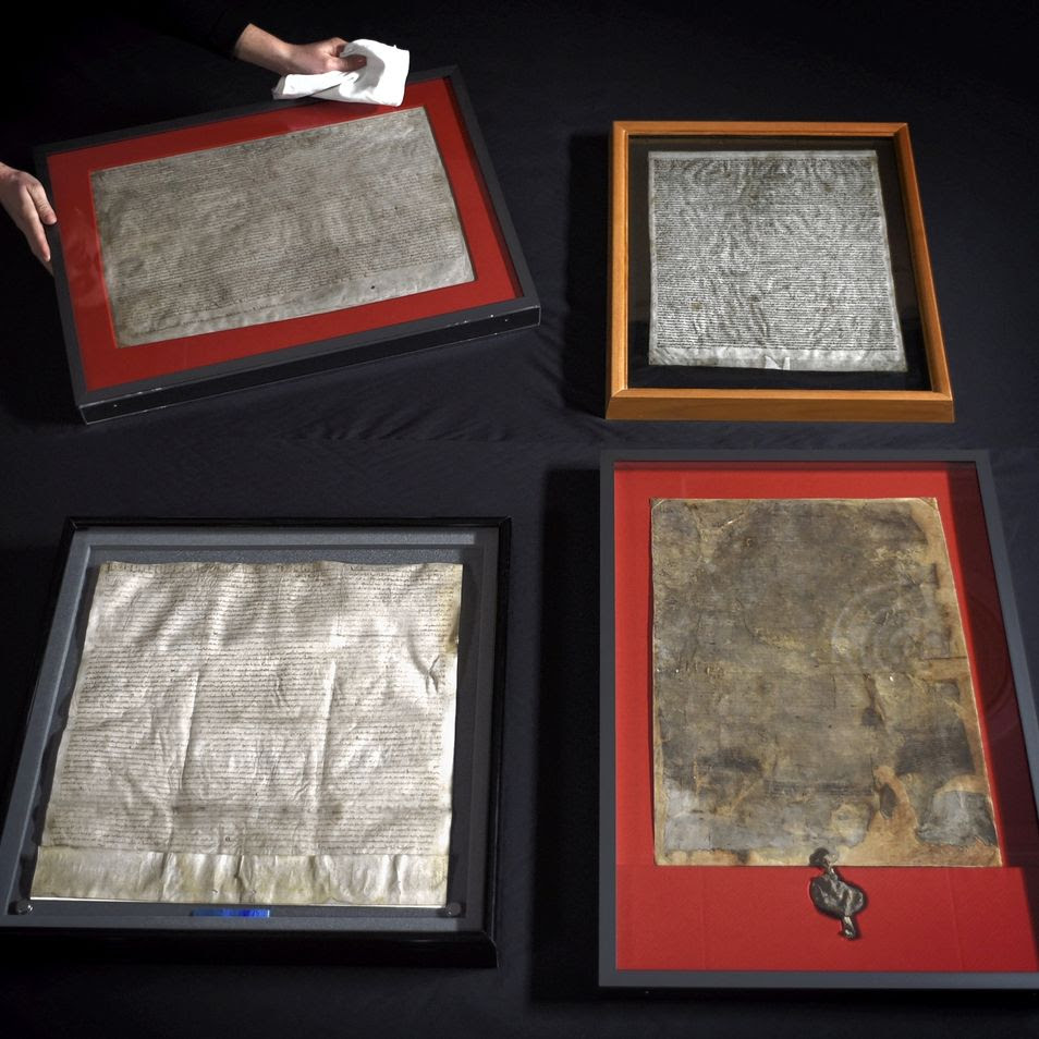 United for the first time, the four surviving original Magna Carta manuscripts are prepared for display at the British Library, London, Feb. 1, 2015.