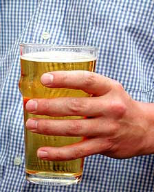Hombre con un vaso de cerveza lager en la mano