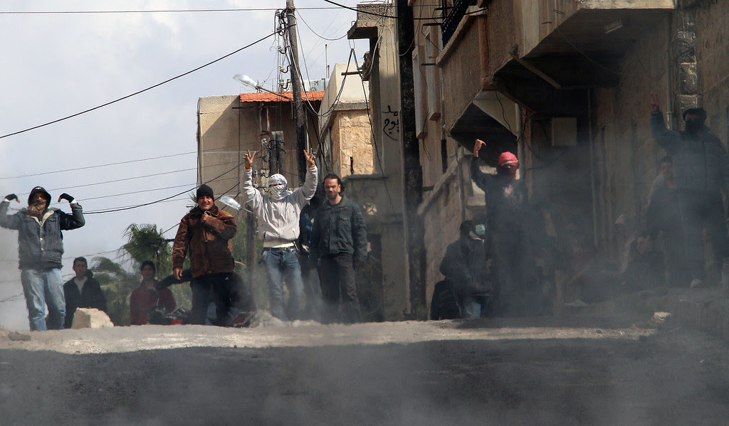 Description of . Anti-government protesters gesture on the streets of Daraa, 100kms south of the capital Damascus on March 23, 2011. Three people, including an 11-year-old girl, were killed this afternoon in the volatile Syrian city of Daraa, witnesses said, as state media reported President Bashar al-Assad had fired the city's governor. ANWAR AMRO/AFP/Getty Images