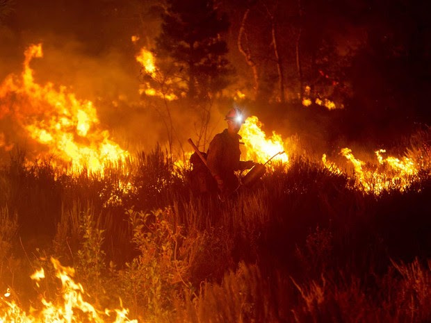 Bombeiros ateiam fogo controlado em mata como estratégia para conter o avanço de um incêndio florestal perto de Pine, em Idaho, EUA. (Foto: Kyle Green/Idaho Statesman/AP)