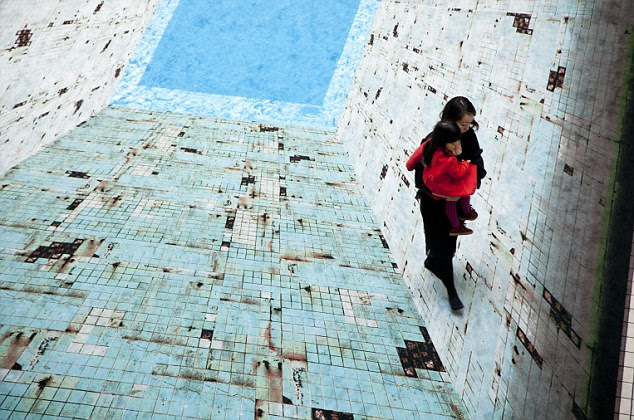 Slippery surface: A mother and child appear to be 'climbing' the walls of the swimming pool