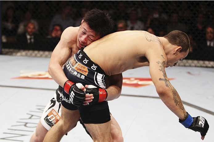 SINGAPORE - JANUARY 04:   Tatsuya Kawajiri  goes for a takedown on Sean Soriano in their featherweight bout during the UFC Fight Night event at the Marina Bay Sands Resort on January 4, 2014 in Singapore. (Photo by Mitch Viquez/Zuffa LLC/Zuffa LLC via Getty Images)