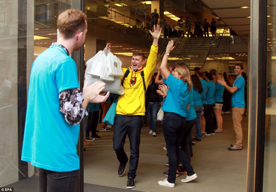 High-five: A customer leaves with one of the first iphone 6 handsets from the Apple store in Regents Street, central London, England, today after waiting in line all week