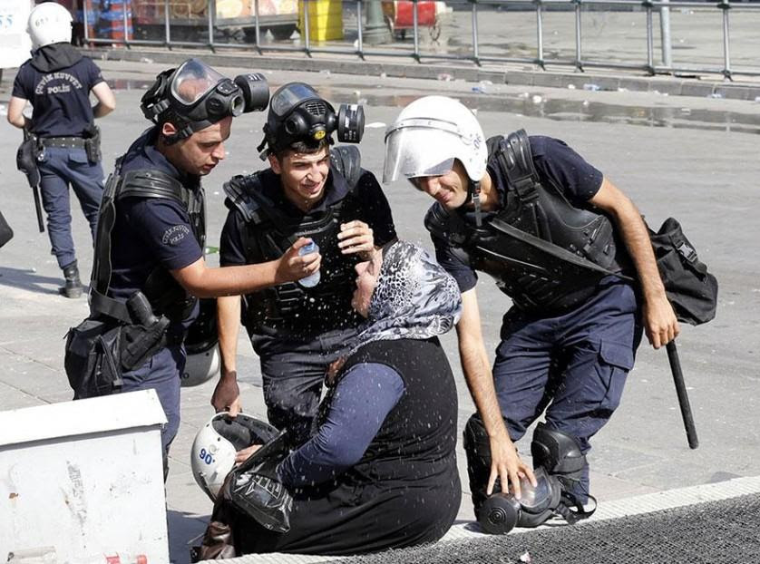 Polícia ajuda uma mulher atingida por gás lacrimogêneo em Ancara, Turquia, 2013
