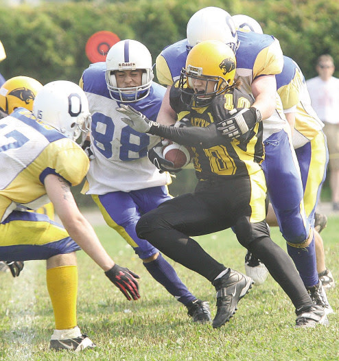 Fredericton High School Black Kats back Simon Bissonnette is hemmed in by 