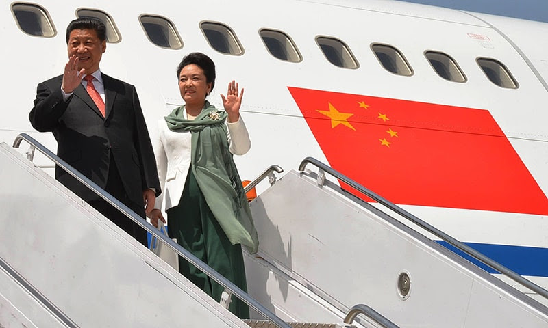 Chinese President Mr Xi Jinping and the First Lady Peng Liyuan wave upon their arrival in the capital amid a grand welcome. —AFP
