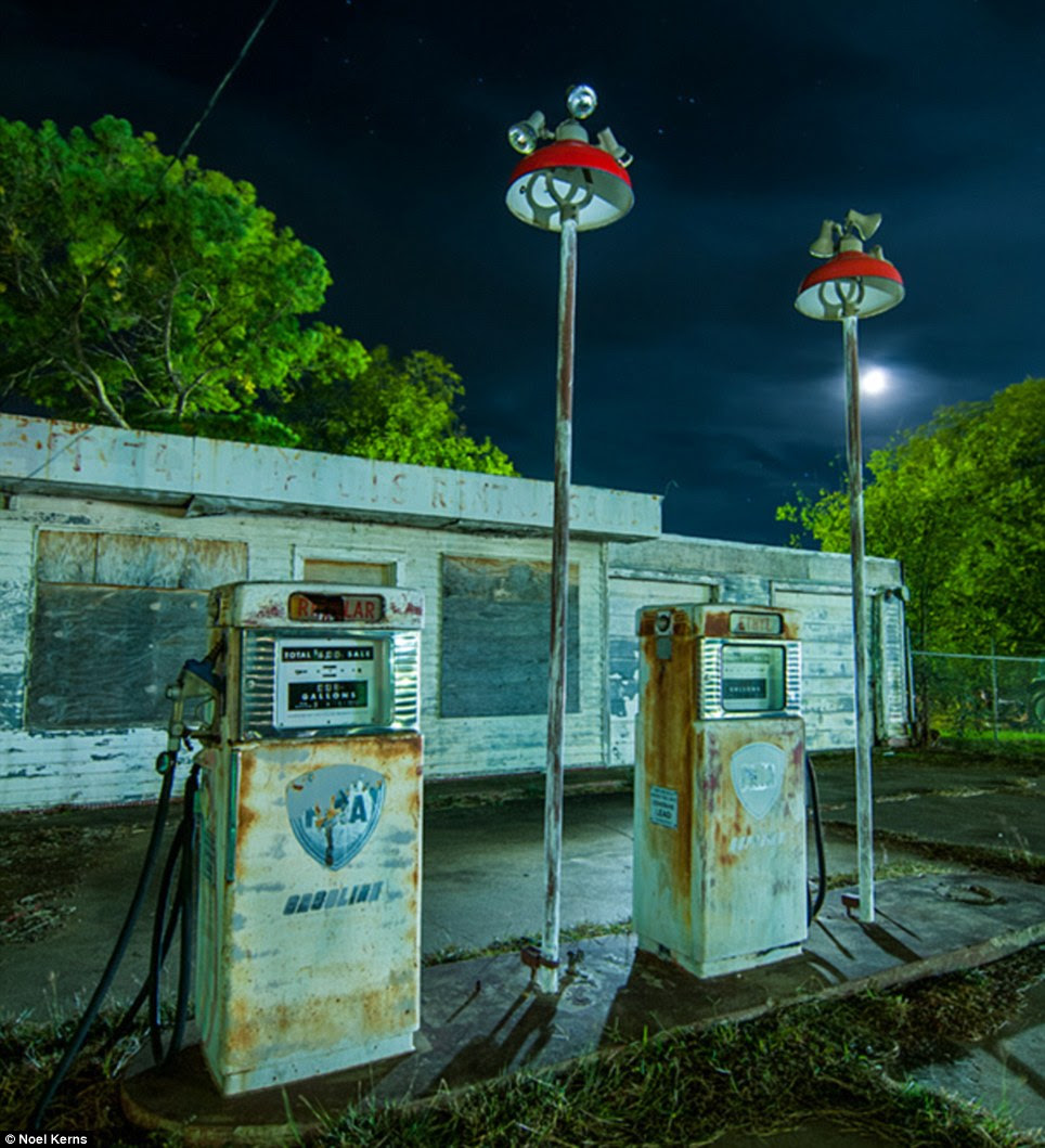 Abandoned gas station on the edge of Mineral Wells, Texas: It is dark with a 1/2 moon, ambient light of all kinds from several directions, CTO-gelled NEBO Redline flashlight and Noel uses a Mercury-vapor lamp behind the building to light up the trees