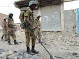 Army troops use metal detectors to look for IEDs planted in a Miranshah street. PHOTO: ISPR