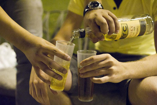 Varios jóvenes se sirven whisky en un botellón en Madrid. | EL MUNDO