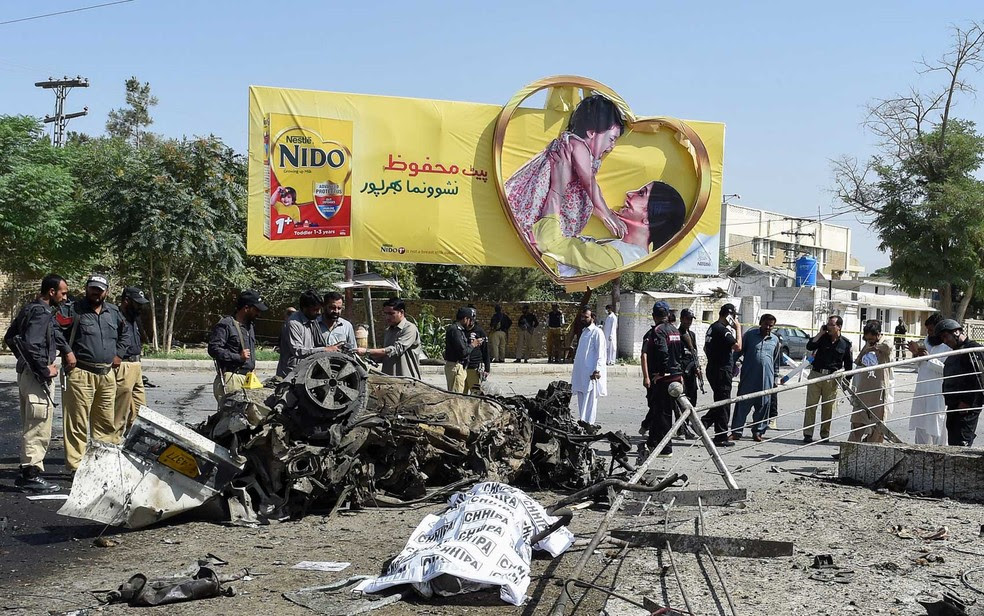 Um corpo coberto no local de explosão em Quetta (Foto: Banaras Khan / AFP Photo)