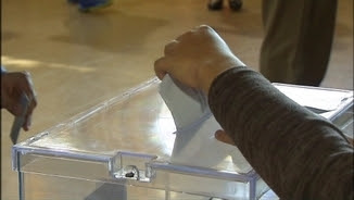 Una persona diposita el seu vot en una urna