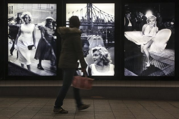 A commuter inspects the Sam Shaw's photographs during the "Marilyn in New York" exhibit at the 42nd St. subway station for the B,D,F,M and 7 lines, Thursday, Dec. 20, 2012 in New York. The exhibit is part of the Metropolitan Transportation Authority's “Arts for Transit” program. The show opened Thursday and will be up for a year. (AP Photo/Mary Altaffer)