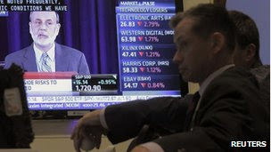 A trader watches US Federal Reserve Board Chairman Ben Bernanke's news conference on the floor of the New York Stock Exchange 18 September 2013