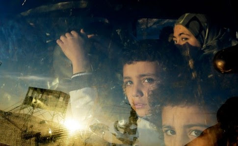 Crianças sírias cruzam, num carro, fronteira para Líbano. Possível ataque dos EUA só tornará aindaa pior uma guerra dramática 