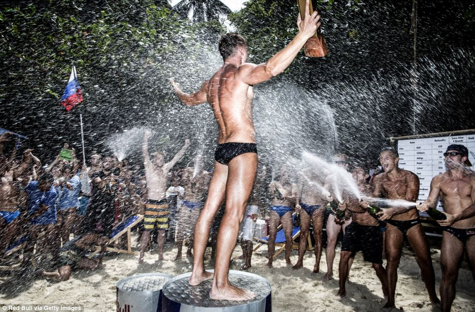 Champion: Silchenko stands on the podium as the other divers spray him with champagne and fans wave flags, lauding his success