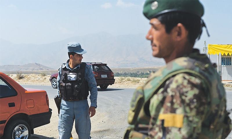 AN Afghan National Army soldier (right) and a policeman keep a close watch on a checkpoint near the Marshal Fahim National Defence University, a training complex on the outskirts of Kabul, on Wednesday.—AFP