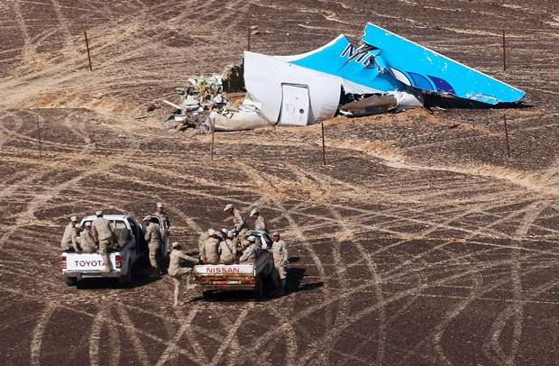 Militares egípcios vistoriam a cauda do avião russo que caiu na Península do Sinai; a foto foi divulgada no dia 2 de novembro de 2015 pelo Ministério das Situações de Emergência russo (Foto: Maxim Grigoriev/Russian Ministry for Emergency Situations/AP)