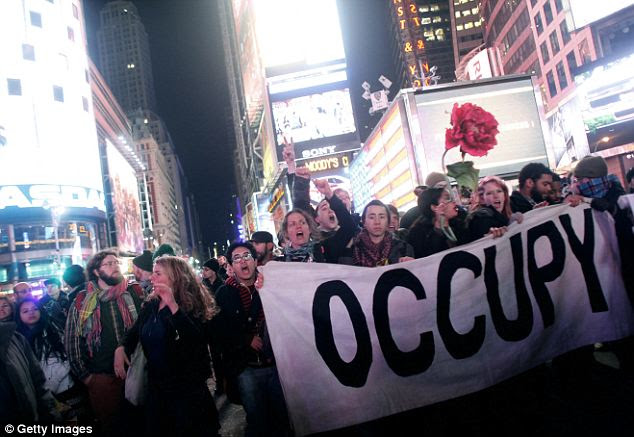 Occupy Wall Street activists demonstrate last week in Times Square, in New York City. Activists marked the three-month anniversary to the Occupy Wall Street movement with speeches and performances.