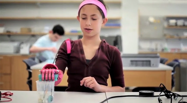 A girl uses a robot arm