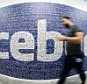 This picture taken with a fisheye lens shows a man walks past a big logo created from pictures of Facebook users worldwide in the company's Data Center, its first outside the US in Lulea, Sweden.  The company began construction on the facility in October 2011 and went live on June 12, 2013 and are 100% run on hydro power.    AFP PHOTO/JONATHAN NACKSTRAND        (Photo credit should read JONATHAN NACKSTRAND/AFP/Getty Images)