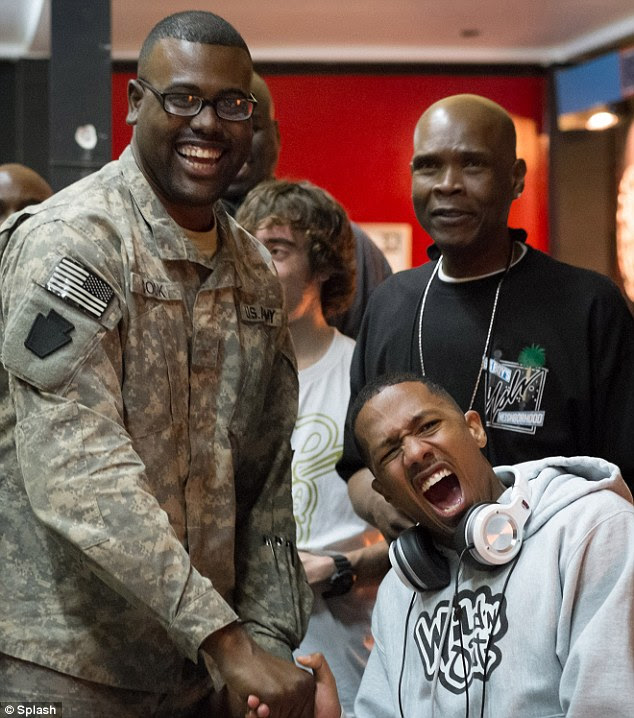 Hamming it up: The funnyman made this soldier laugh when he feigned pain from his powerful grip