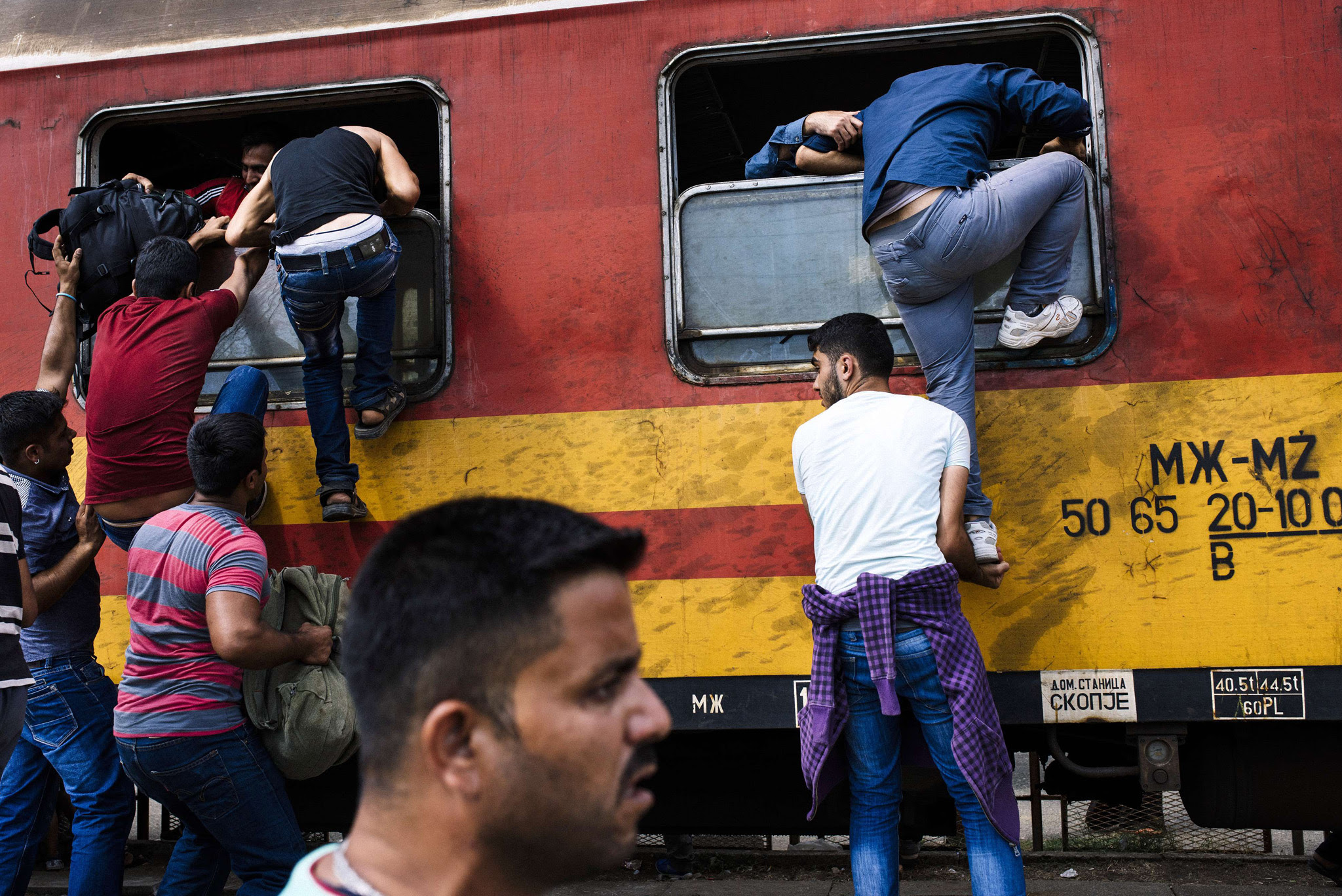 Migrants try to get on a train heading to the border with Serbia at the train station in Gevgelija, on the Macedonian-Greek border. According to the UN, some 224,000 migrants and refugees have crossed the Mediterranean to Europe so far this year. 