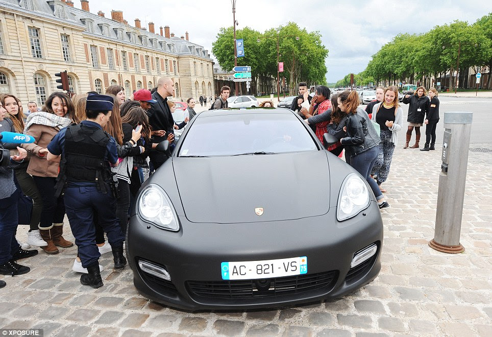Here they come: Kanye drives his wife-to-be towards the Palace of Versailles as eager fans try to get a picture
