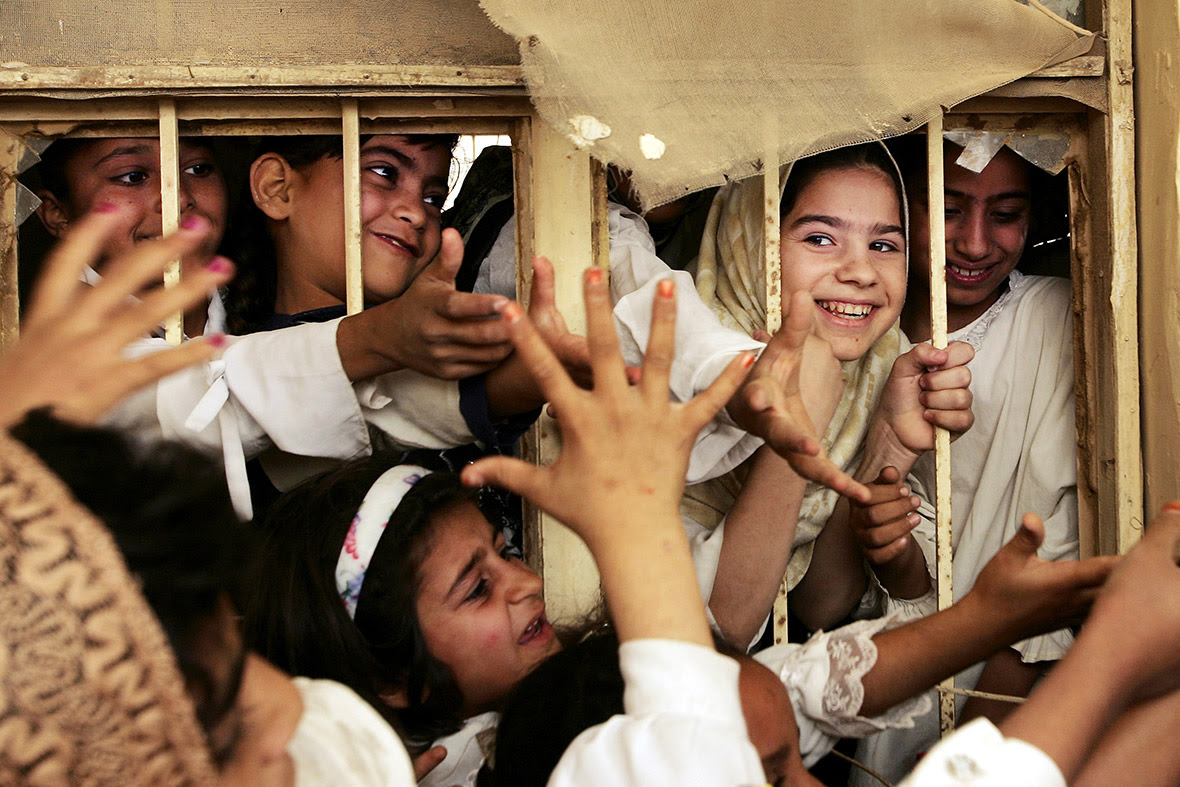 June 12, 2005: Schoolgirls reach out for presents handed out by US troops at a girls' school in Fallujah, Iraq