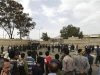 People gather in front of the gates of the police academy where a suicide bomb attack took place in Sanaa