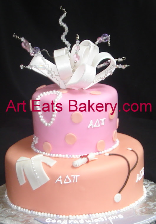 Two tier orange and pink fondant Clemson cake with lab coat, diploma, stethoscope, pearls, bow and crystal topper.jpg