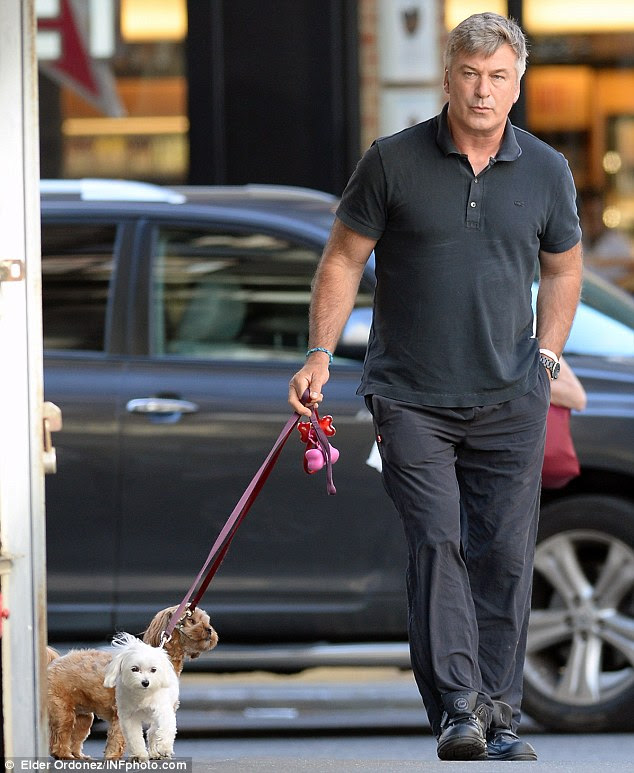 Duty calls: Alec took his and Hilaria's two dogs out for a walk on Saturday, just one day after baby Carmen's birth