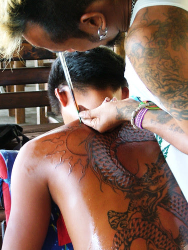 Picture of guy getting traditional Thai tattoo in a tattoo bar