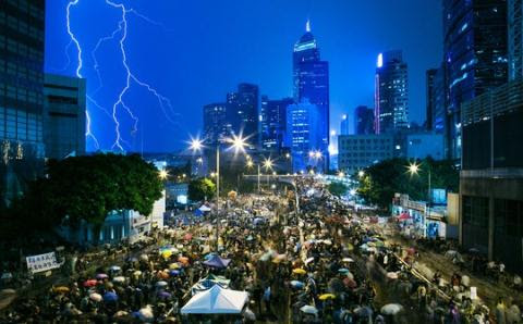 Người biểu tình Hồng Kông đội mưa ngồi dưới lòng đường