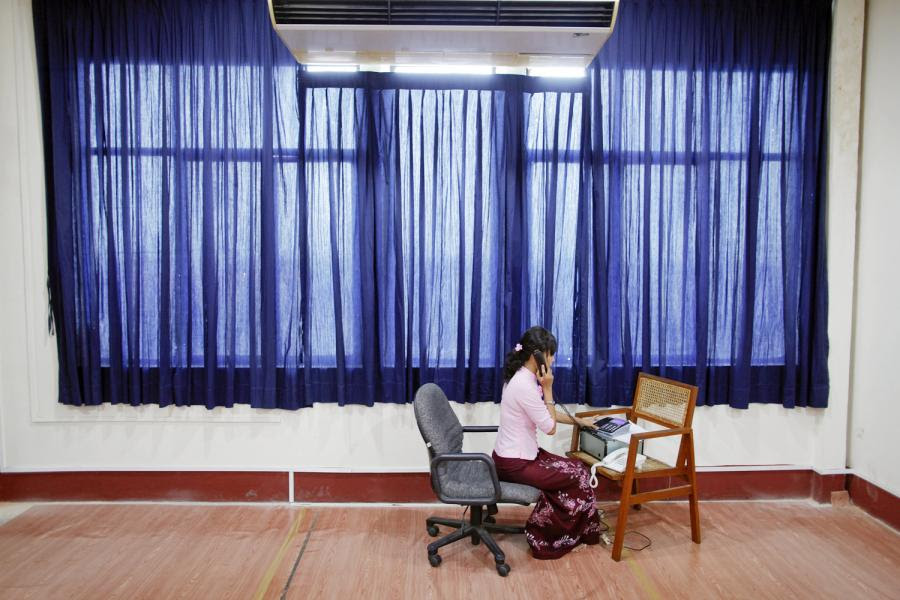An employee speaks on a phone at room for daily foreign exchange auctions at Myanmar's central bank in Yangon