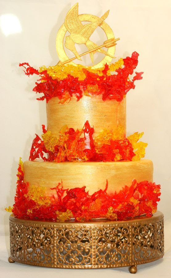 Boiled sugar flames with a gum paste topper.  Cake is handpainted in gold, orange and red.  Made for Hunger Games Challenge.
