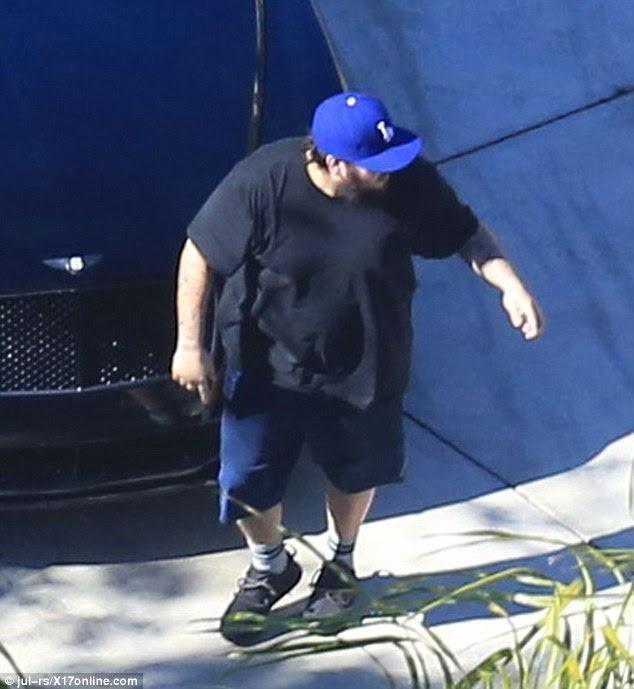 Covering up his physique: The youngest Kardashian wore a loose black T-shirt and blue shorts 