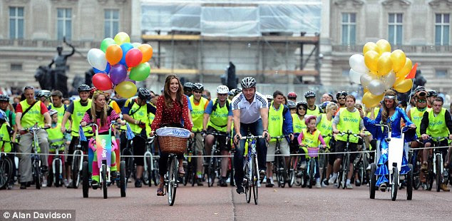 Leading the crowds: Kelly and Sir Chris Hoy start Skyride off with thousands of cyclists ready to follow them
