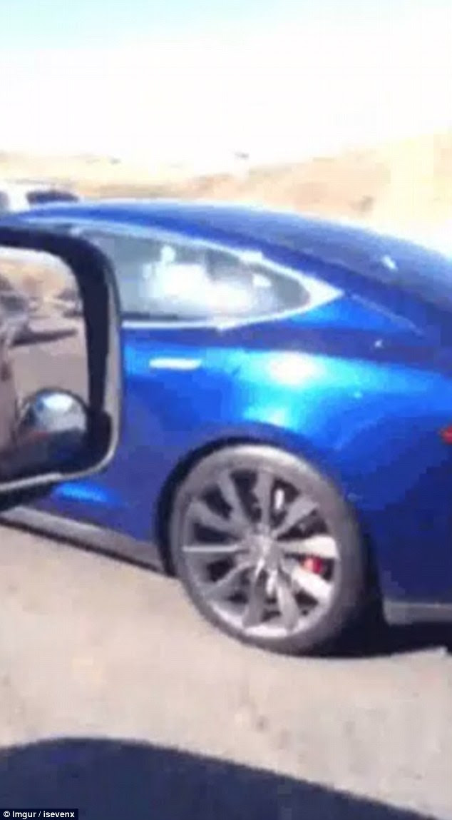 Moving right along: The Tesla idles along at a typical traffic speed as the driver appears to take a nap