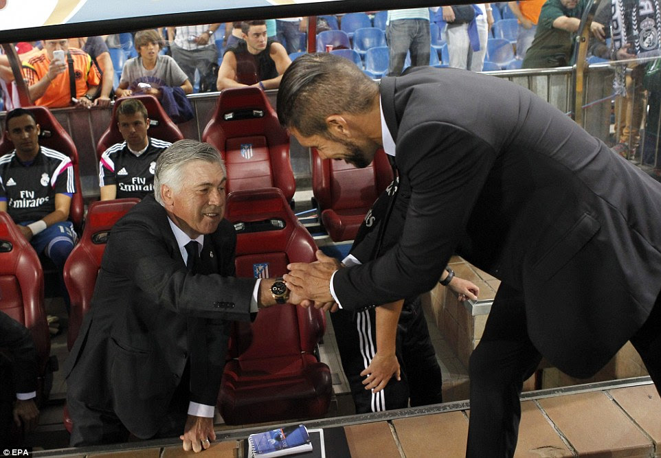 Best of enemies: Atletico coach Diego Simeone (right) greets his Real Madrid counterpart Carlo Ancelotti (left) before the match
