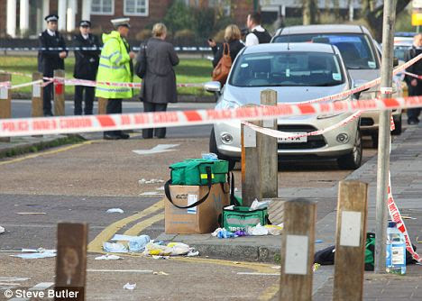 Cordoned off: Metropolitan Police officers at the scene of the attack, with a paramedic's kit visible in the foreground