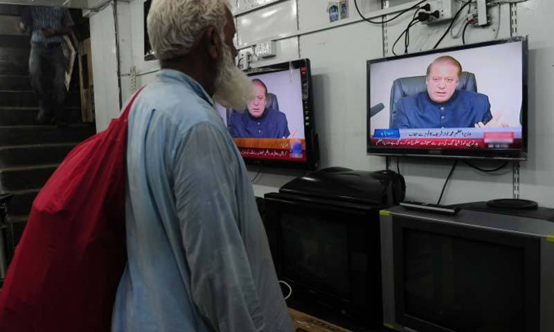 Photo shows a man watching a television screen tuned to Geo News.—File Photo
