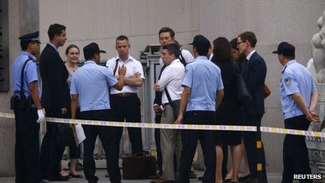 Policemen speak to diplomats at the entrance of a court where the appeal verdict of Liu Hui is announced, in the Huairou district of Beijing, 16 August 2013