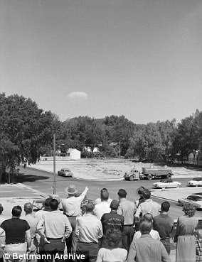 Residents of Las Vegas watch the mushroom cloud of a distant test of an atomic bomb.