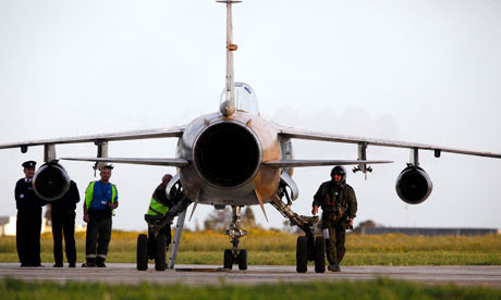 Libyan airforce pilot walks next to his Mirage F1 fighter jet after landing in Malta